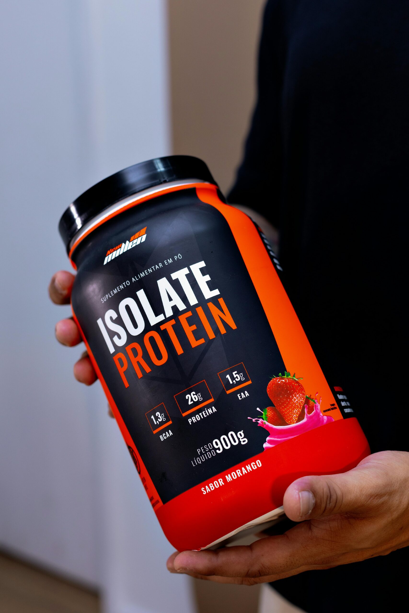 Close-up of a hand holding an Isolate Protein container in Belo Horizonte, Brazil.